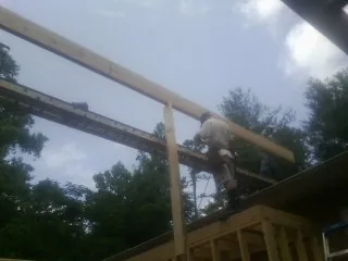 Carpenter setting a ridge beam over a new addition frame — Ice Dam Removal by Roofing Brothers in Portis