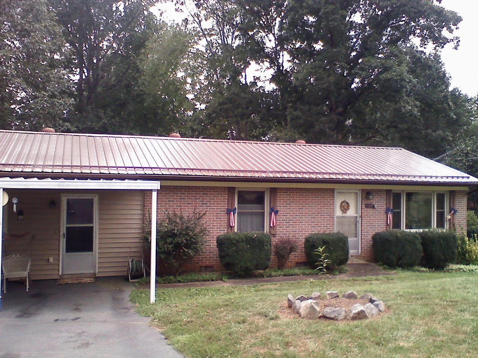 Bronze metal roof and carport on a brick ranch home — Roof Repair work by our crew in Portis