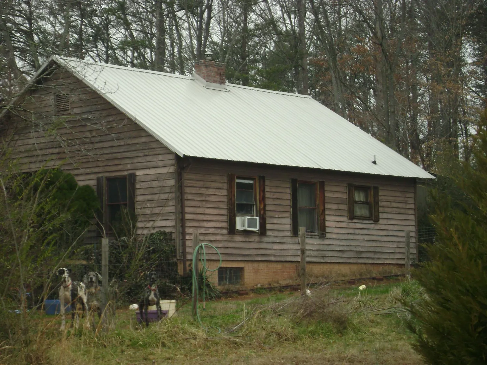 White metal roof on an old wood sided farmhouse, from a Metal Roof Installation job in Portis
